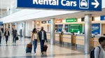 Traveler with luggage standing at a car rental counter inside Philadelphia Airport in Pennsylvania
