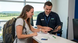 Person reviewing car rental paperwork and holding keys next to a vehicle in Pennsylvania