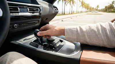 Close up of a driver's hand on the gear selector and parking brake of a Florida car rental