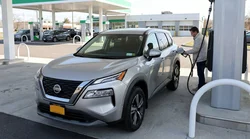 Person filling the gas tank of a car rental at a New York gas station