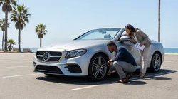 Silver car rental parked on a sunny California highway showing the tires, windshield and underbody
