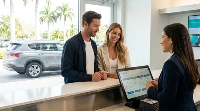 Customer signing documents at a Miami car rental counter next to an electronic toll pass