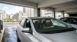 Driver in a car rental approaching a highway toll booth in New York