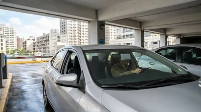 Driver in a car rental approaching a highway toll booth in New York