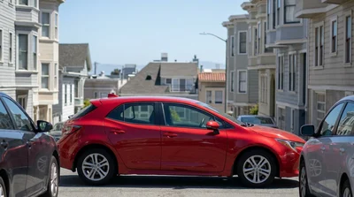 Compact car rental parked in a tight space on a steep San Francisco hill