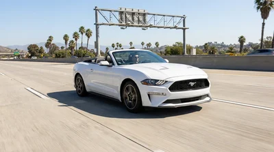 Silver car rental driving on a sunny multi-lane highway in California approaching a toll plaza