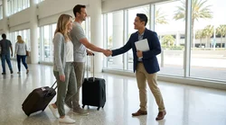 Traveler receiving car rental keys from a smiling representative outside the Orlando Airport terminal