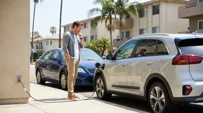 Modern electric car rental parked on a residential Los Angeles street lined with palm trees