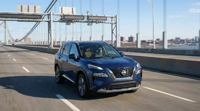 Silver car rental approaching a highway toll booth in New York