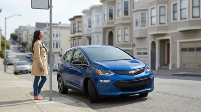 Silver car rental parked on a steep San Francisco street next to Victorian houses