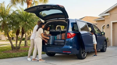 Suitcases loaded into the open trunk of a 7-seater car rental parked under Florida palm trees