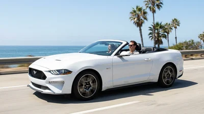 Silver car rental driving along a scenic coastal highway with ocean views in California