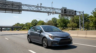 White car rental driving under an overhead electronic toll gantry in New York