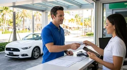 Customer holding a physical credit card at a car rental desk in Miami