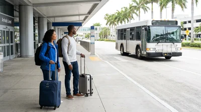 Passengers with luggage board a car rental shuttle bus outside the Tom Bradley Terminal at LAX in Los Angeles