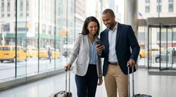 Woman using a smartphone while standing next to a car rental on a New York street