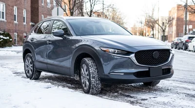 Close up of winter tires on a black car rental parked on a snowy street in New York