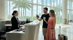 Close-up of hands exchanging a license and keys at a car rental desk in Florida