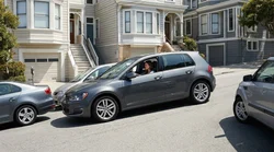 Compact car rental squeezed into a tight parking spot on a steep hill in San Francisco