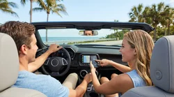 Driver touching an Apple CarPlay dashboard screen inside a car rental in sunny Florida