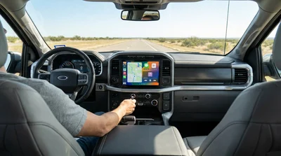Car rental dashboard showing a connected smartphone screen on a Texas highway