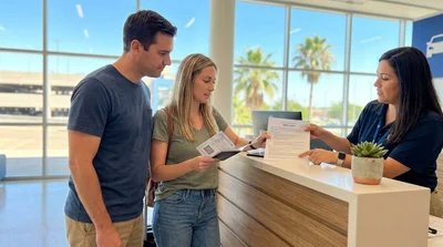 Person holding a passport photocopy and keys at a car rental desk in Texas