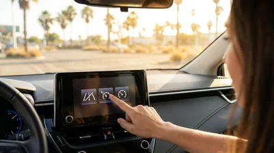 Driver adjusting the steering wheel controls inside a car rental on a palm-lined street in Los Angeles