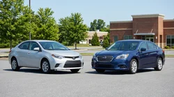 An intermediate sedan and a larger standard car parked side by side at a Pennsylvania car rental lot