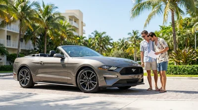Low angle view of a white car hire parked on a sunny palm-lined street in Miami