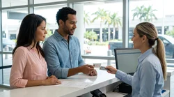 A person handing a driving licence to an agent at a car rental office in Miami