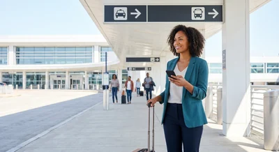 A lone traveler looks for signs at the modern Philadelphia Airport exterior, navigating to the car hire pick-up.