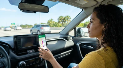Driver uses phone navigation in Orlando rental car.
