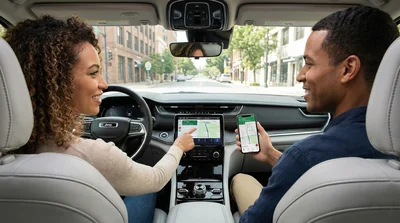 Couple inside a rental car comparing smartphone maps with the built-in GPS navigation system during their car hire trip.