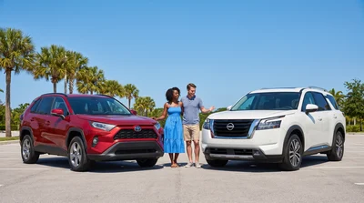 Two modern SUVs, one standard and one full-size, parked side-by-side in sunny Florida for car rental comparison.