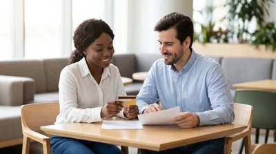 Couple review documents and credit card for United States car hire contract.
